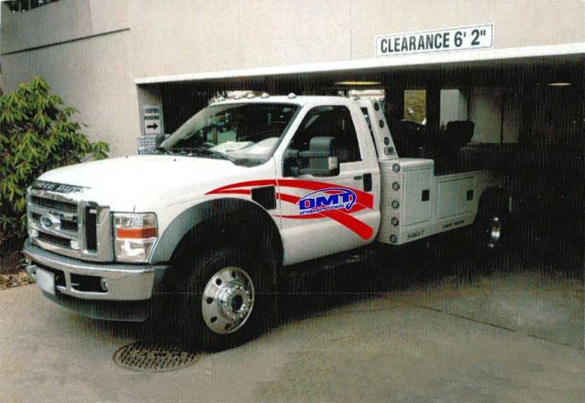 Ottawa Metro Towing truck entering a low clearance parking garage marked 6'2" height limit